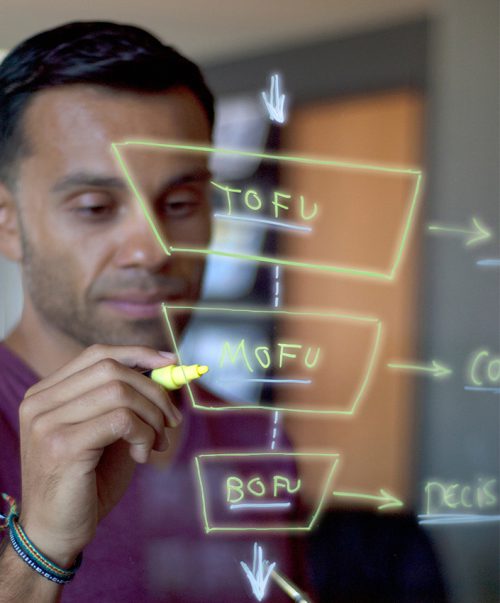 man writing on a lightboard in clear daylight